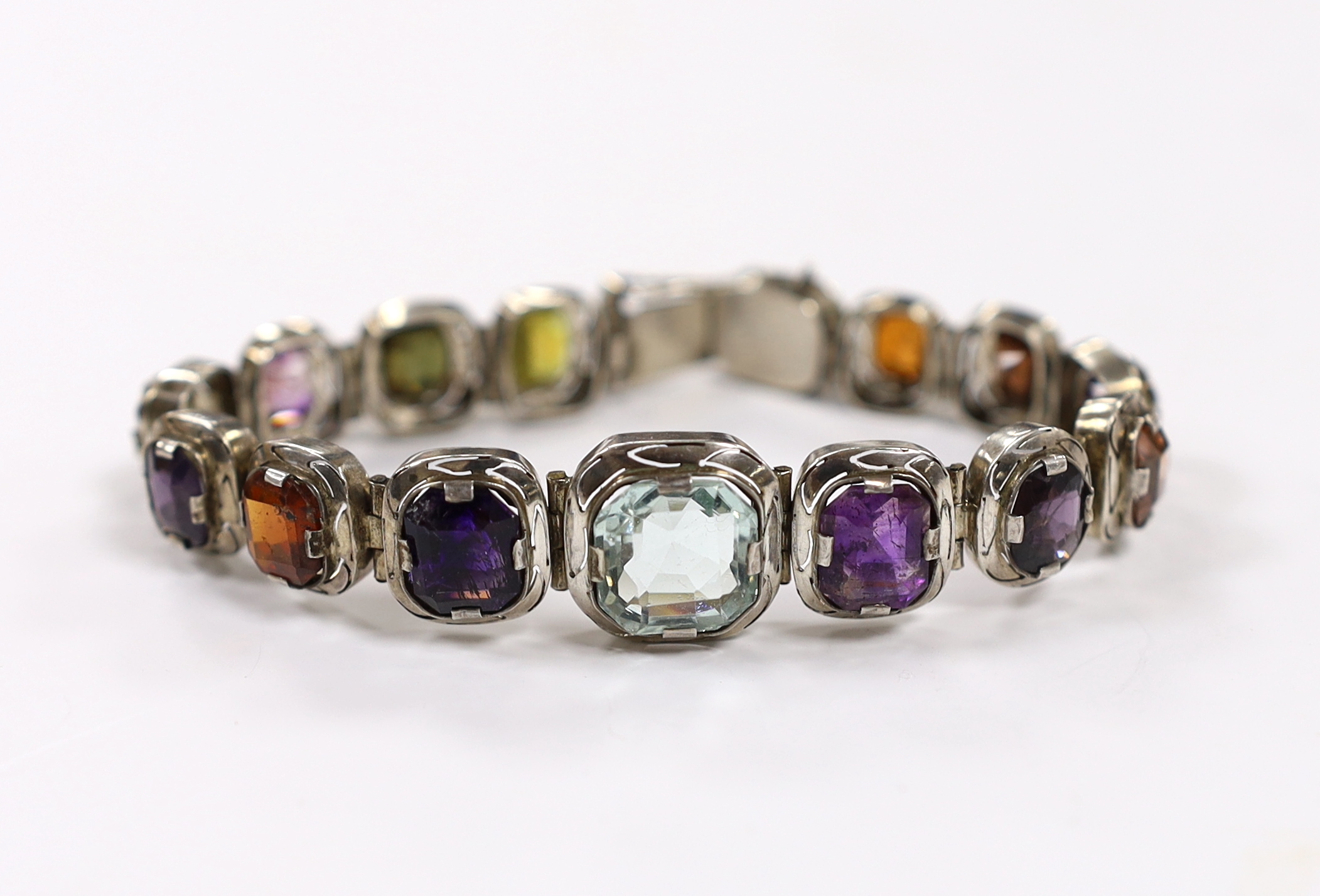 A white metal (tests as silver) and graduated multi gem set bracelet, 17.5cm